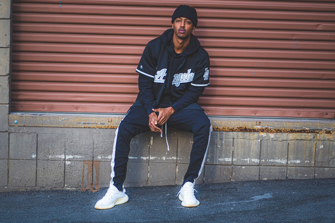 A stylish streetwear outfit featuring layered clothing, comfortable sneakers, and accessories, set against an urban backdrop.