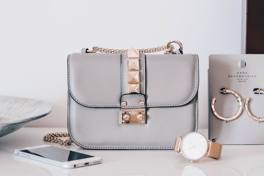 A stylish handbag placed next to a chic outfit on a hanger, showcasing a blend of colors and textures.