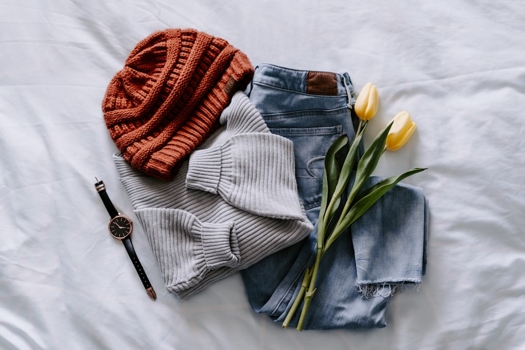 A stylish woman wearing a comfortable casual outfit, standing in a relaxed outdoor setting, showcasing a blend of wardrobe essentials like a simple top, jeans, and accessories.